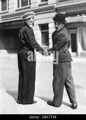 JACKIE COOGAN visite CHARLIE CHAPLIN en costume comme le champ sur le candid pendant le tournage du RÉALISATEUR / producteur / écrivain / musique MODERN TIMES 1936 FILM silencieux CHARLES CHAPLIN avec des effets sonores Charles Chaplin Productions / United Artists Banque D'Images