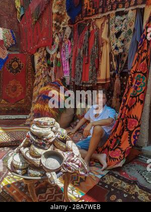 Jeune homme touristique dans un vieux magasin traditionnel de tapis turcs dans la maison grotte Cappadocia, Turquie Kapadokya Banque D'Images
