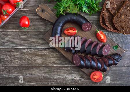 Morsilla - saucisse de sang. Morceaux de pouding noir espagnol sur un tableau de découpe en bois. Menu de Pâques. La vue de dessus Banque D'Images