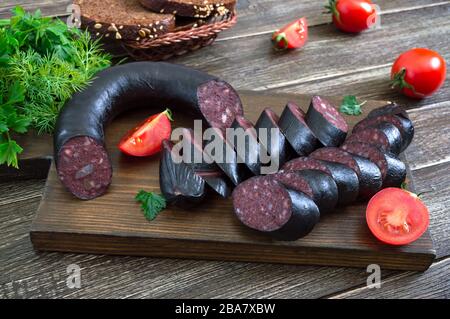 Morsilla - saucisse de sang. Morceaux de pouding noir espagnol sur un tableau de découpe en bois. Menu de Pâques. Banque D'Images