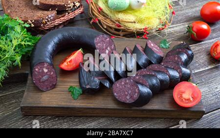 Morsilla - saucisse de sang. Morceaux de pouding noir espagnol sur un tableau de découpe en bois. Menu de Pâques. Banque D'Images