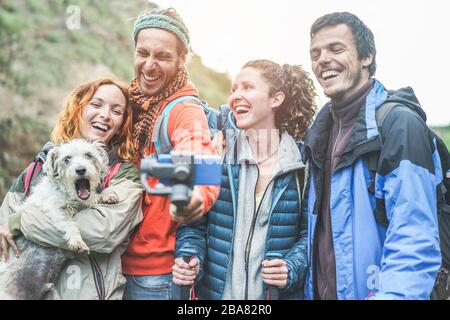 Heureux trekkers les gens qui font de la vidéo vlog avec le téléphone de gimbal - jeunes amis randonneurs s'amuser le jour de l'excursion en montagne - tendances technologiques et le sport con Banque D'Images