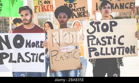 Groupe de manifestants millénaires sur la route, les jeunes de différentes cultures et races luttent pour la pollution plastique et le changement climatique - Global Warm Banque D'Images