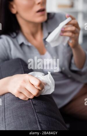 vue rognée d'une femme allergique éternuant et tenant des serviettes Banque D'Images