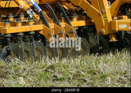 Tracteur avec herse Simba à disque électrique cultivant un champ latéral avant de planter avec du maïs à Devon, avril Banque D'Images