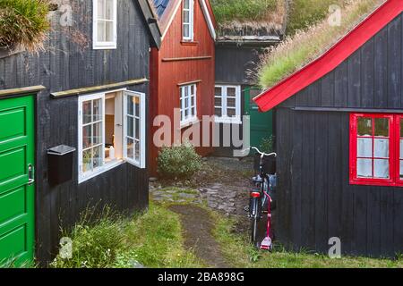 Maisons traditionnelles en bois Féroé avec gazon herbe noire toit. Village pittoresque Banque D'Images