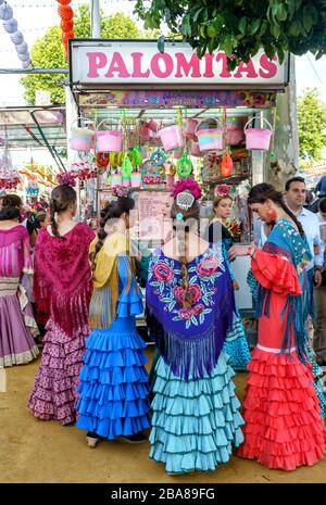 Les filles portent une robe de flamenco traditionnelle et des friandises pour faire du shopping à la foire d'avril Banque D'Images