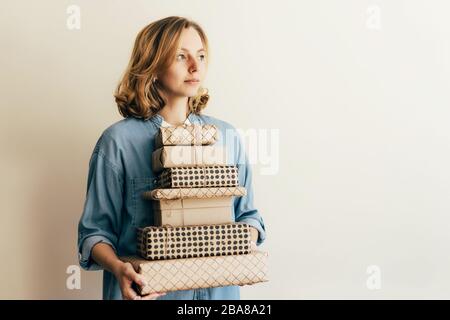De nombreux cadeaux et achats entre les mains d'une jolie femme blanche. Banque D'Images