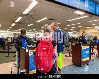 Orlando,FL/USA-3/21/20: Les gens qui traversent l'aéroport international d'Orlando MCO sécurité TSA dans les masques un jour lent en raison du coronavirus. Banque D'Images