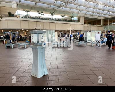 Orlando,FL/USA-3/21/20: Les gens qui traversent l'aéroport international d'Orlando MCO sécurité TSA un jour lent en raison du coronavirus avec une aseptisation à la main Banque D'Images