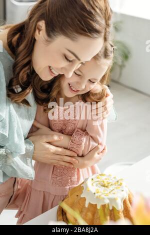 foyer sélectif d'une heureuse femme embrassant la fille tout en regardant le gâteau de pâques Banque D'Images