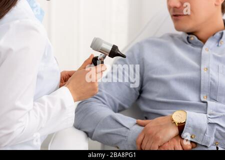 vue rognée de l'otoscope du médecin proche du patient Banque D'Images