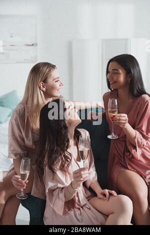 Foyer sélectif de femmes multiculturelles avec des verres de champagne à la fête de Bachelorette dans la chambre Banque D'Images