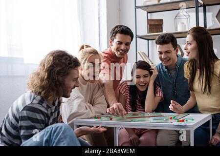 KIEV, UKRAINE - 27 JANVIER 2020: De jeunes amis enthousiastes jouant le jeu de monopole chez eux Banque D'Images