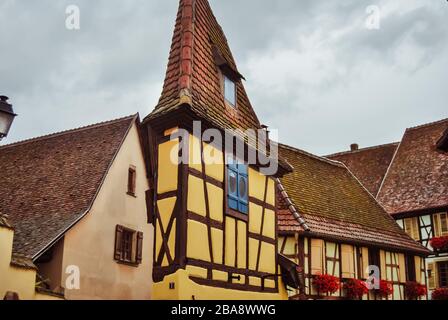 Jolie petite ruelle fleurie avec ses maisons traditionnelles, à Eguisheim, en Alsace Banque D'Images