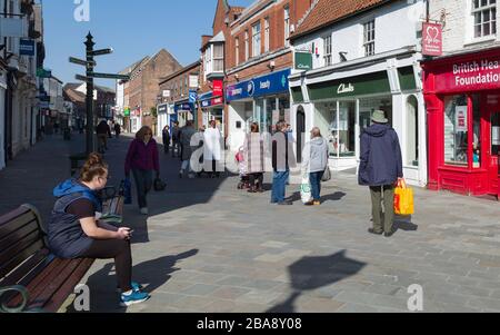 Les gens font la queue pour entrer dans la pharmacie après la fermeture de la plupart des magasins pendant l'épidémie de virus Corona à Beverley, Yorkshire, Royaume-Uni. Banque D'Images