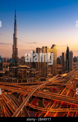 Vue sur la ville de Dubaï avec Burj Khalifa et Sheikh Zayed Road au crépuscule, aux Émirats arabes Unis. Banque D'Images