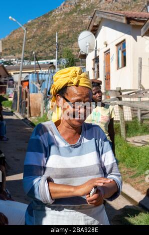 Femme souriante et garçon marchant sur l'une des routes dans le canton surpeuplé d'Imizamo Yethu, la baie de Hout, le Cap, Afrique du Sud Banque D'Images