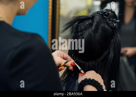 Femme professionnelle appliquant des extensions de cheveux avec différents types de poignées. Nano bagues extensions en véritables cheveux d'huma. Banque D'Images