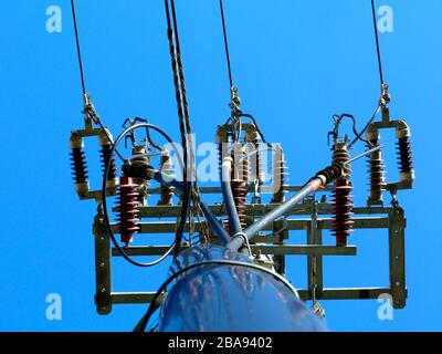 fils électriques sur le mât en béton. câbles tombant verticalement. ciel bleu. câbles électriques aériens et vérins d'isolateur en céramique. alimentation Banque D'Images