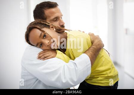 Médecin ayant une conversation avec une fille triste à l'hôpital. Médecin consolant enfant Banque D'Images