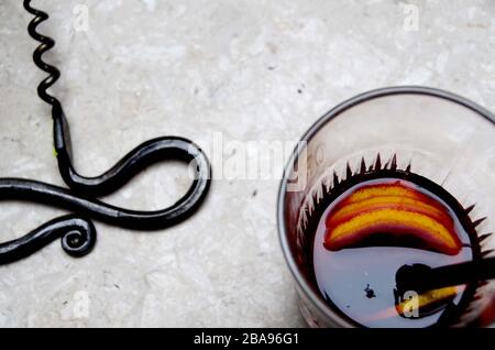 Impression avec un vieux tire-bouchon en fer forgé à la main et un verre avec une boisson - presque ivre. Banque D'Images