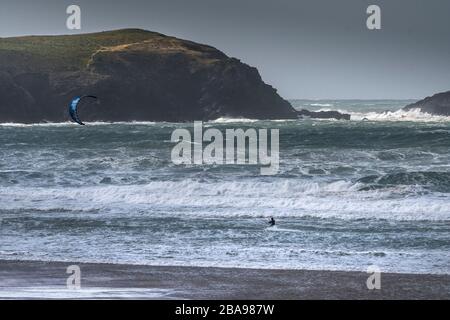 Un surfeur de kite solitaire bravant les conditions venteuses sauvages à Fistral, à Newquay, en Cornwall. Banque D'Images