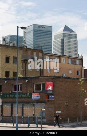 Derlict pub, East India Dock Road, Poplar Tower Hamlets, Londres avec Tower blocs de Canary Wharf, quartier financier, derrière. Le quartier de Londres de T Banque D'Images