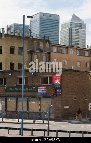 Derlict pub, East India Dock Road, Poplar Tower Hamlets, Londres avec Tower blocs de Canary Wharf, quartier financier, derrière. Le quartier de Londres de T Banque D'Images