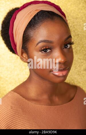 Portrait d'une jeune femme noire portant un bandeau et regardant l'appareil photo. Banque D'Images