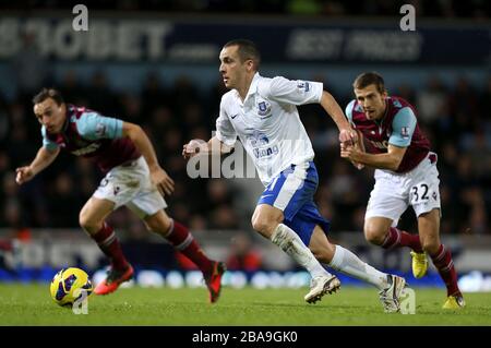 Leon Osman (au centre) d'Everton fait une course avec le ballon devant James Tomkins (à gauche) de West Ham United et Gary O'Neil (à droite) Banque D'Images