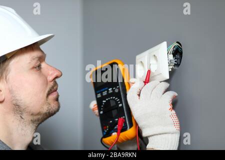 L'électricien du casque mesure le niveau d'électricité Banque D'Images