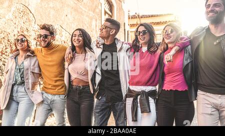 Concept d'unité et de cohésion des jeunes multiraciaux embrassant ensemble. Des amis de différentes courses marchent ensemble mains sur les épaules en plein air Banque D'Images