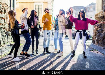 Les jeunes ayant un sourire amusant et dansant ensemble dans la rue. Jeunesse célébrant la liberté et le concept d'Union multiraciale. Banque D'Images