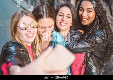 Groupe de quatre filles multiraciales prenant selfie avec leur style de vie de smartphone. Femme amitié style de vie concept. Heureux studen multiethnique du millénaire Banque D'Images