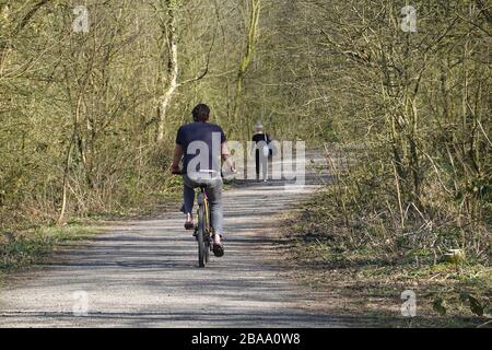 New Mills, Derbyshire Mars. 26 2020 UN cycliste effectue une promenade tranquille le long du sentier Sett Valley à New Mills pendant le coronavirus, qui balaie à travers le pays. Le gouvernement a une politique de séjour à domicile, mais permet l'exercice une fois par jour. Les cyclistes sont ravis qu'il y ait si peu de voitures sur la route. Banque D'Images