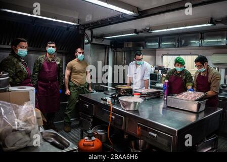Barcelone, Espagne. 25 mars 2020. Les officiers préparent la nourriture dans la cuisine de Fira pour les sans-abri à Barcelone, ??Espagne, le 25 mars 2020. L'Espagne est l'un des pays les plus touchés par l'épidémie de Coronavirus (Covid-19). (Photo de Adrià Salido Zarco/INA photo Agency/Sipa USA) crédit: SIPA USA/Alay Live News Banque D'Images