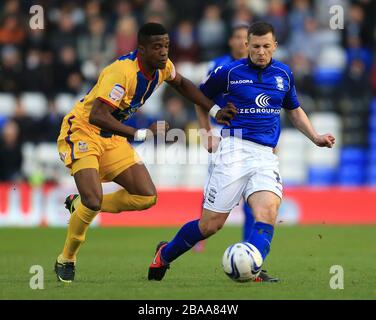 Paul Caddis (à droite) de Birmingham City et le Zaha (à gauche) de Crystal Palace en action Banque D'Images