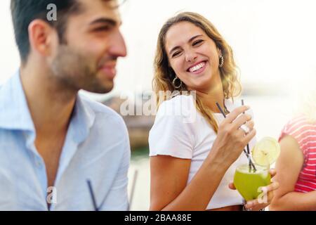 Les jeunes s'amusent sur une table de bar pour discuter et boire des cocktails. Concept de style de vie des jeunes Banque D'Images