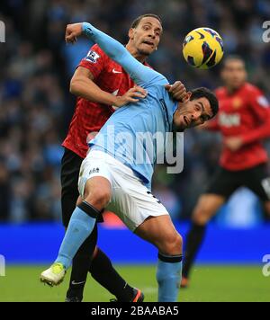 Carlos Tevez de Manchester City (à droite) et Rio Ferdinand (à gauche) de Manchester United affrontent le ballon Banque D'Images