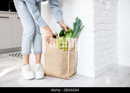 Femme prenant un sac de shopping plein de légumes frais et de légumes verts, vue rapprochée Banque D'Images