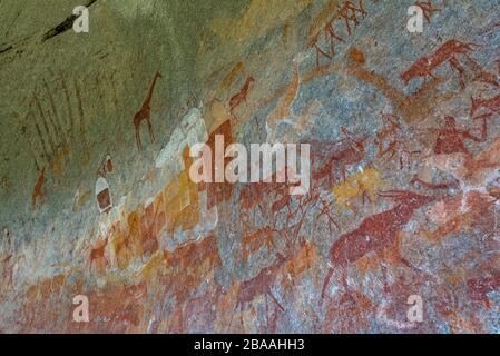 Un touriste admire l'art rupestre de San dans la grotte d'Inanke, parc national de Matobo, Zimbabwe. Banque D'Images