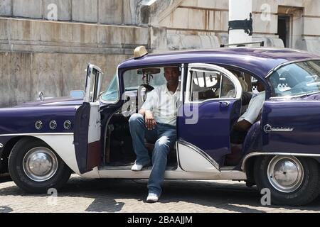 Les chauffeurs de taxi se reposent dans une voiture américaine classique à la Havane Vieja Banque D'Images