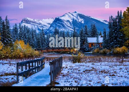 Pigeon Mountain et chalet en bois et pont près du ruisseau Policaemans, Canmore, Alberta, Canada Banque D'Images