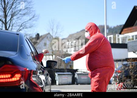 (200326) -- LENNESTADT (ALLEMAGNE), le 26 mars 2020 (Xinhua) -- un travailleur de la santé prend un échantillon d'un conducteur pour tester une éventuelle infection par le COVID-19 à une station d'essai de conduite à Lennestadt, en Allemagne, le 26 mars 2020. Les cas confirmés de COVID-19 en Allemagne ont augmenté de 4 954 en un jour à 36 508, a annoncé jeudi l'Institut Robert Koch (RKI). Selon RKI, l'organisme du gouvernement fédéral et l'institut de recherche responsable du contrôle et de la prévention des maladies, le nombre de décès de la COVID-19 est passé de 149 à 198. (Photo de Ulrich Hufnagel/Xinhua) Banque D'Images