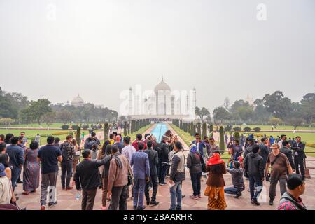 Foules de visiteurs prenant des photos du Taj Mahal en début de matinée, Agra, Uttar Pradesh, Inde Banque D'Images