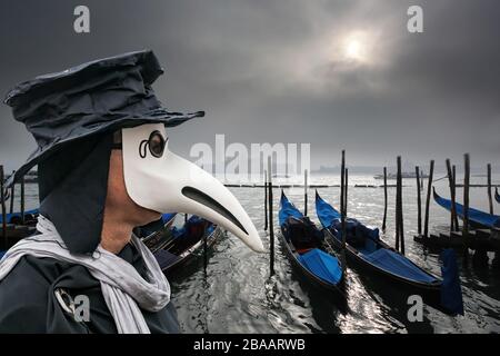 Médecin de peste contre les gondoles pendant la journée de brume à Venise, Italie, symbole de l'épidémie Banque D'Images