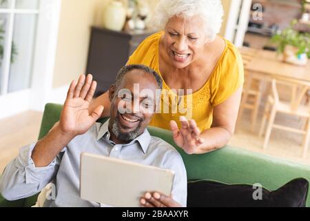 Couple afro-américain senior utilisant une tablette numérique dans un canape Banque D'Images