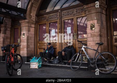 Londres, Royaume-Uni. 26 mars 2020. Les cyclistes se reposent devant le Palace Theatre à partir de trois jours après que le Premier ministre Johnson a demandé à ses compatriotes de laisser leurs propres quatre murs aussi peu que possible. Crédit: Oliver Weiken/dpa/Alay Live News Banque D'Images