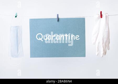 Accroché sur un papier cordelette avec inscription quarantaine et masque médical avec des gants de protection, quarantaine de l'épidémie de Covid-19 de Coronavirus Banque D'Images